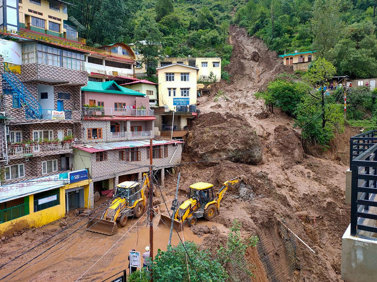 Earthmovers on restoration work as massive landslide damaged buildings at Shamti after heavy monsoon rainfall, in Solan district, on July 11, 2023 | Photo Credit: PTI